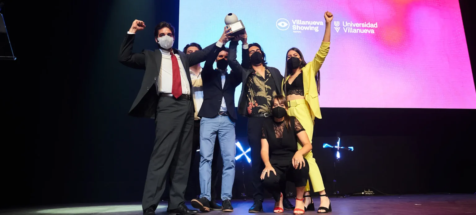 Ganadores celebrando con su trofeo en el escenario del Villanueva Showing Festival