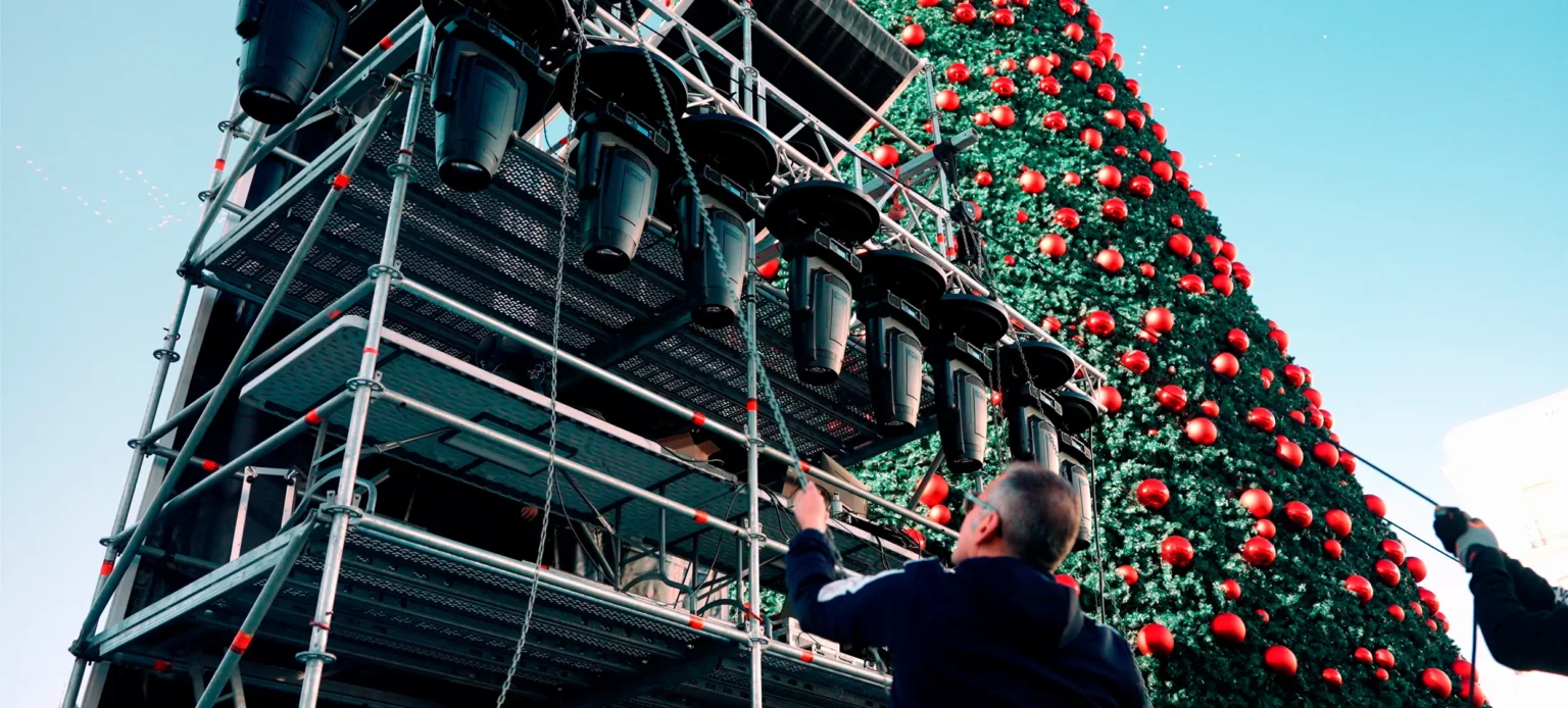 Torre de estructura con altavoces y focos junto al árbol de Navidad en el concierto de Nochevieja con Edurne en Sol