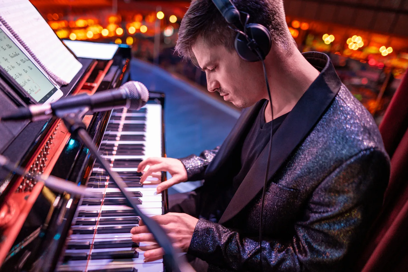 Pianista con chaqueta de lentejuelas tocando en directo en una cena de empresa
