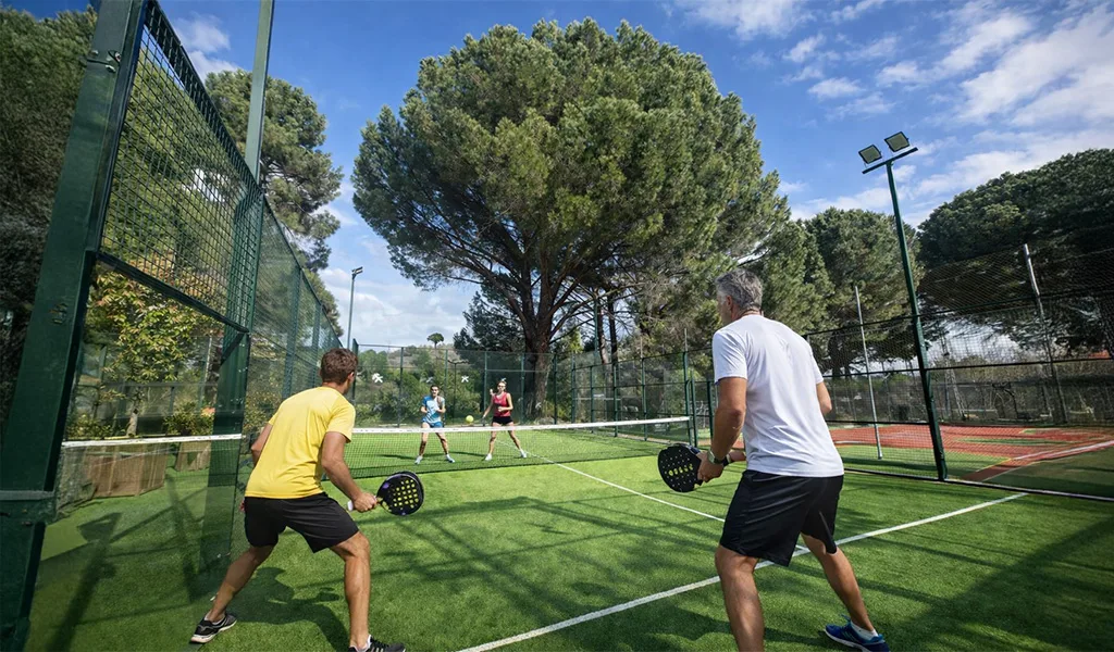 Partido en una de las pistas de pádel de Campus Puente Nuevo entre pinos
