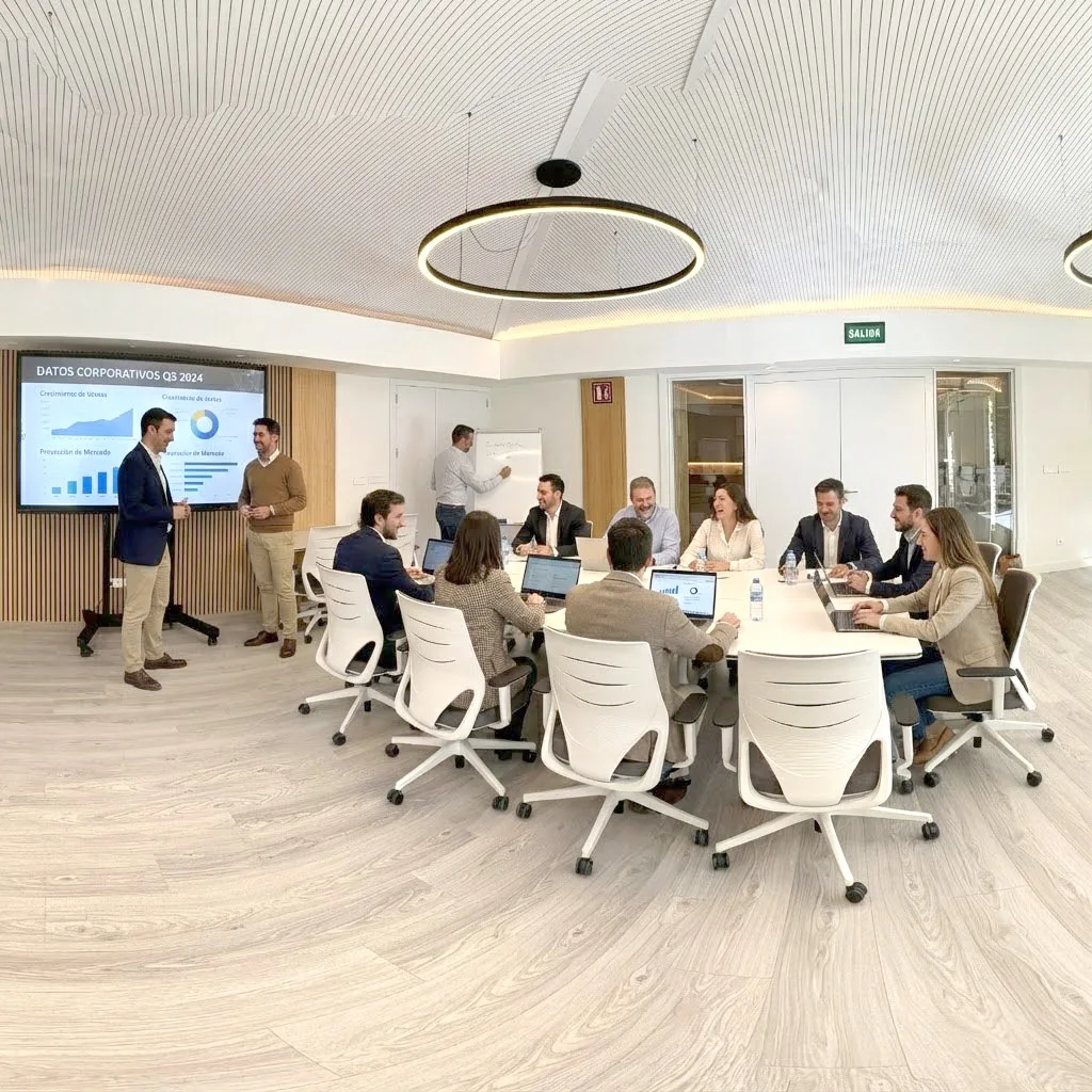 Reunión de trabajo en una sala luminosa de Campus Puente Nuevo con pantalla interactiva