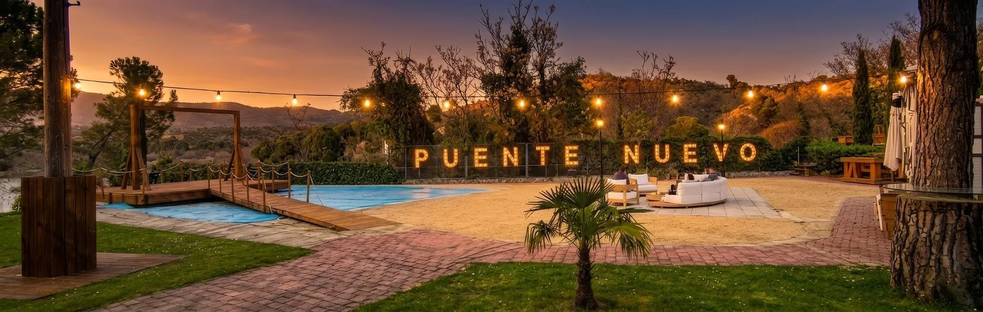 Zona Susi Beach de Campus Puente Nuevo al atardecer, con palmeras y edificios del campus