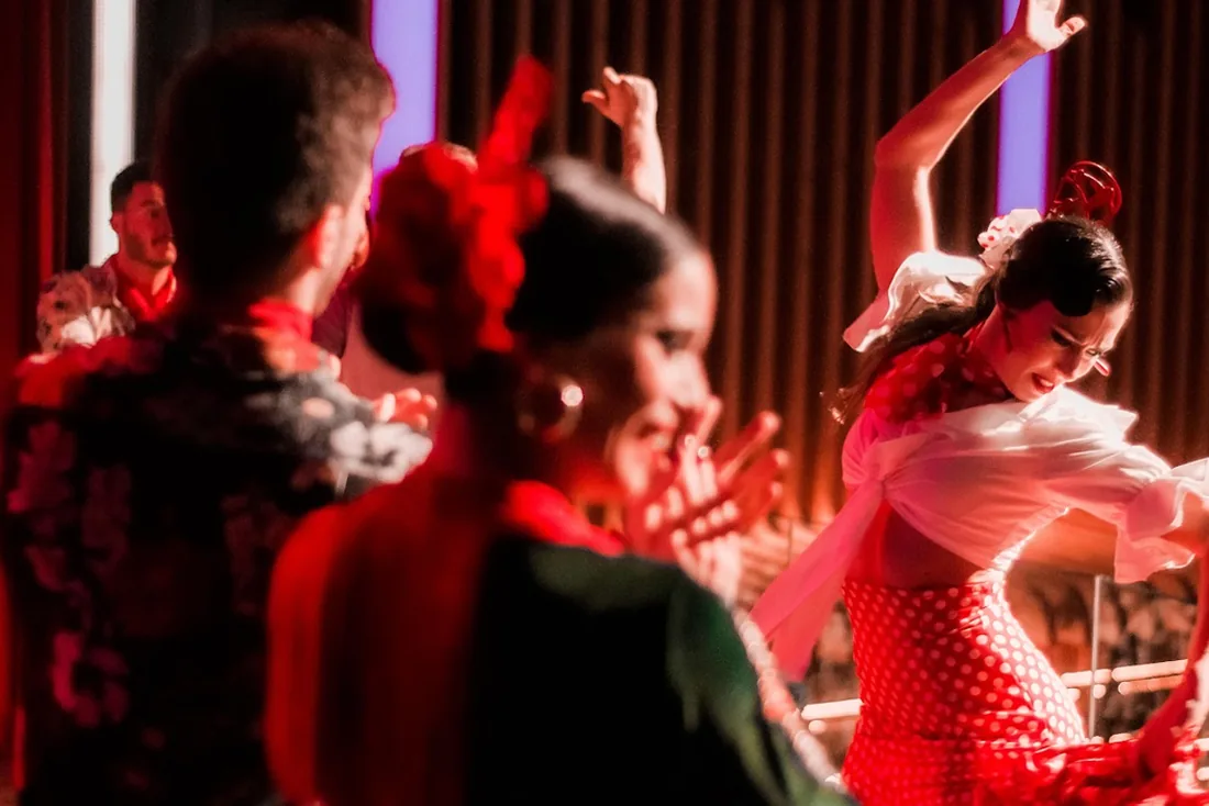 Bailaora con traje de lunares rojo y palmeros en una noche flamenca para empresas