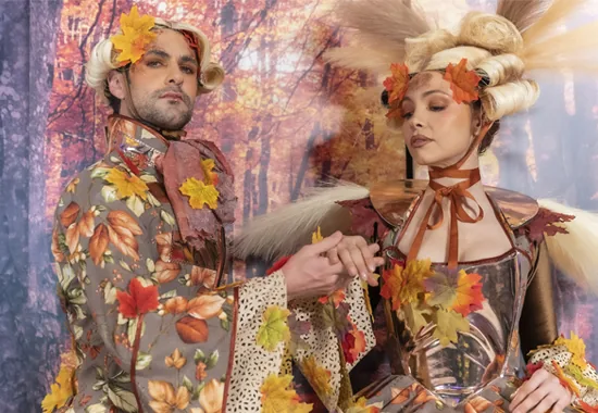 Pareja de artistas con vestuario de hojas de otoño en un espectáculo inmersivo para una gala de empresa