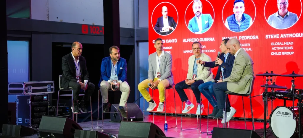 Mesa redonda en el escenario del Music & Sport Summit: ponentes ante una gran pantalla LED, producida por Provocador