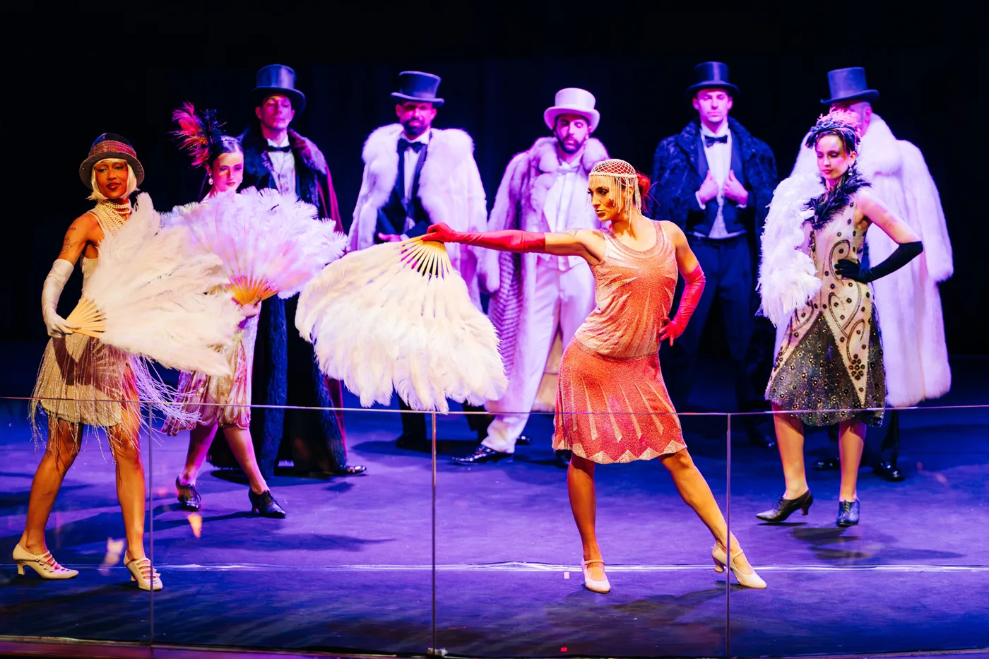 Bailarinas con abanicos de plumas y actores con sombrero de copa en un show de los años 20