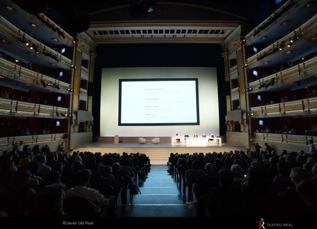 Conferencia corporativa en la Sala Principal del Teatro Real con pantalla en el escenario